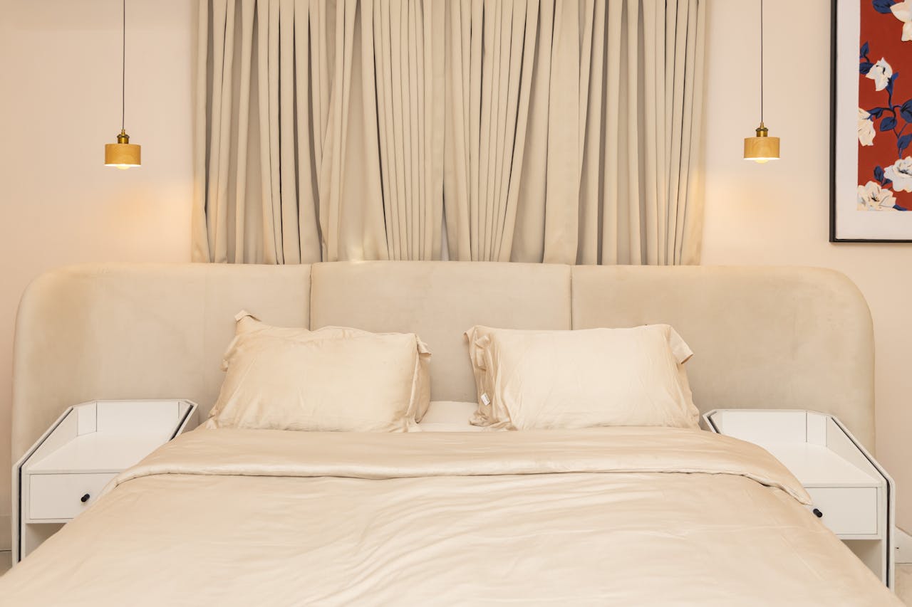A stylish bedroom with neutral tones, soft lighting, and contemporary furniture.