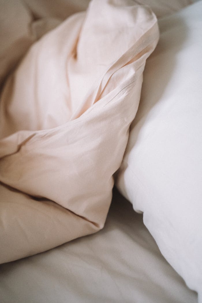 Close-up of soft, crumpled bed linen fabric in a cozy setting.